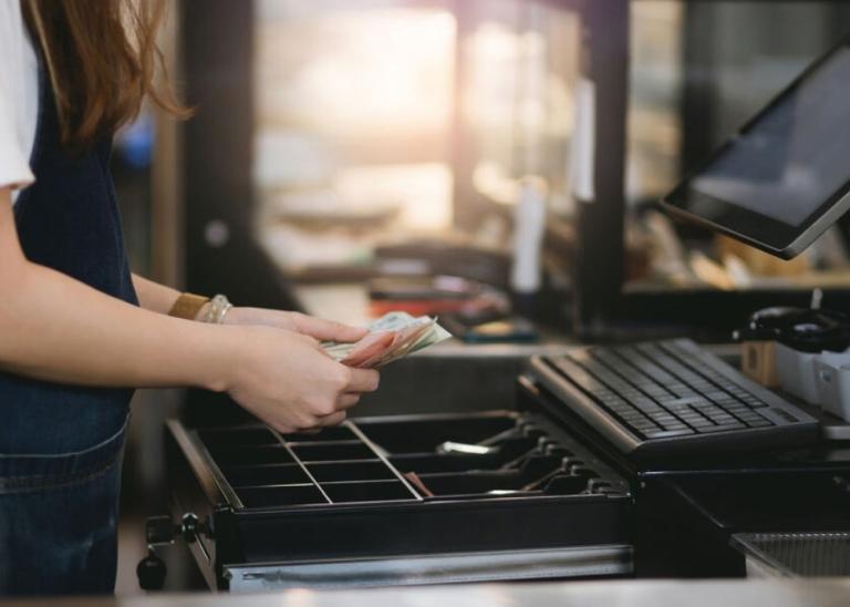cashier handling cash at Point-of-Sale system POS
